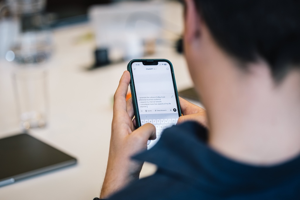 Mitarbeitende nutzen KI-Tools wie ChatGPT auf dem Smartphone im Rahmen eines Corporate Influencer Trainings