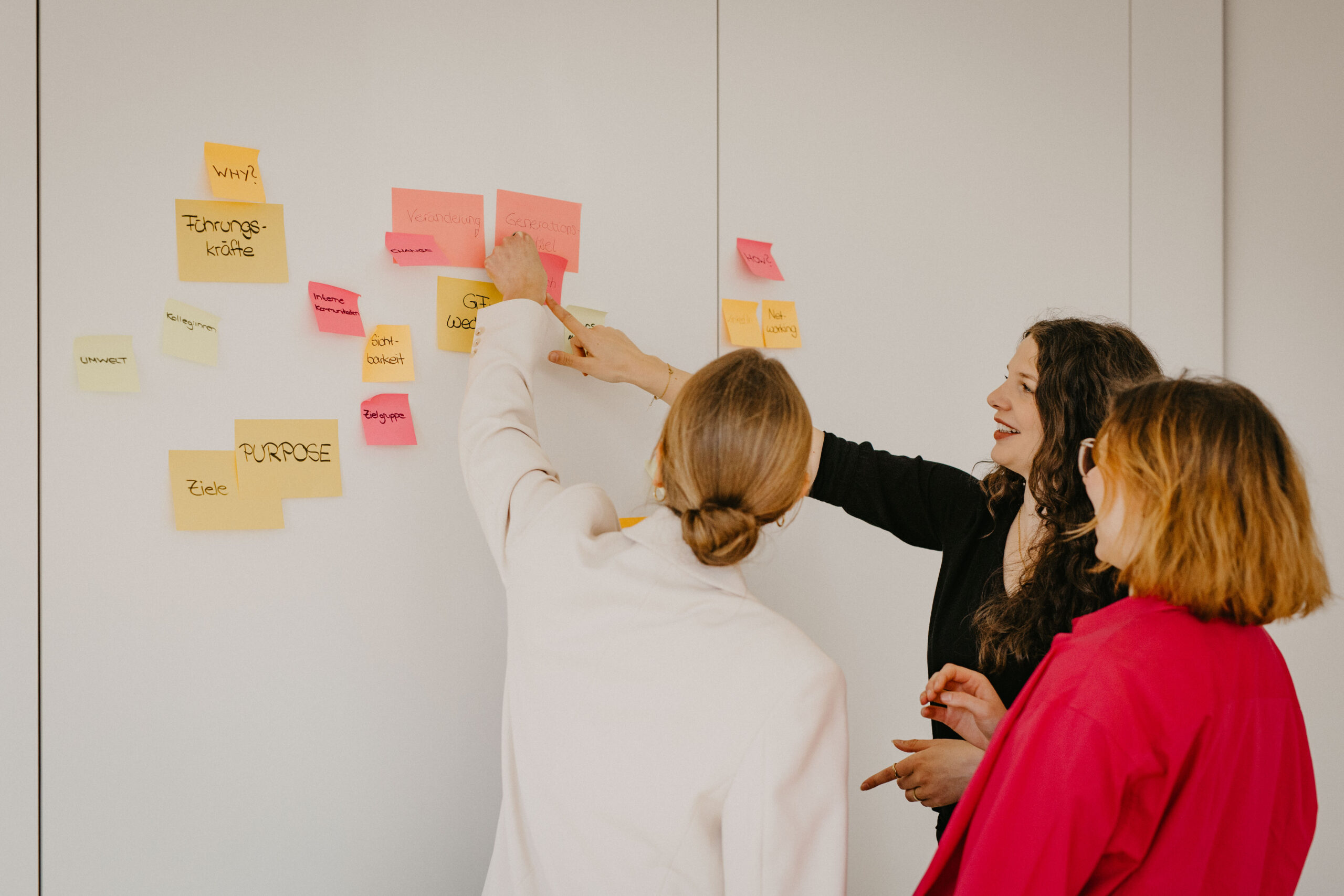 Kommunikationsberaterinnen im Brainstorming mit Haftnotizen während eines Strategie-Workshops.