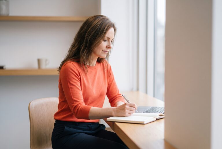 Frau schreibt konzentriert an ihrer LinkedIn About Section am Laptop